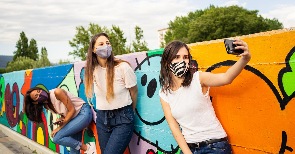 Three friends outdoors in face masks