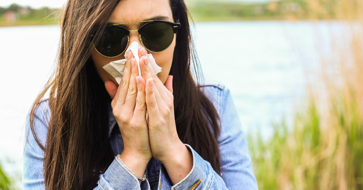 Woman sneezes outdoors
