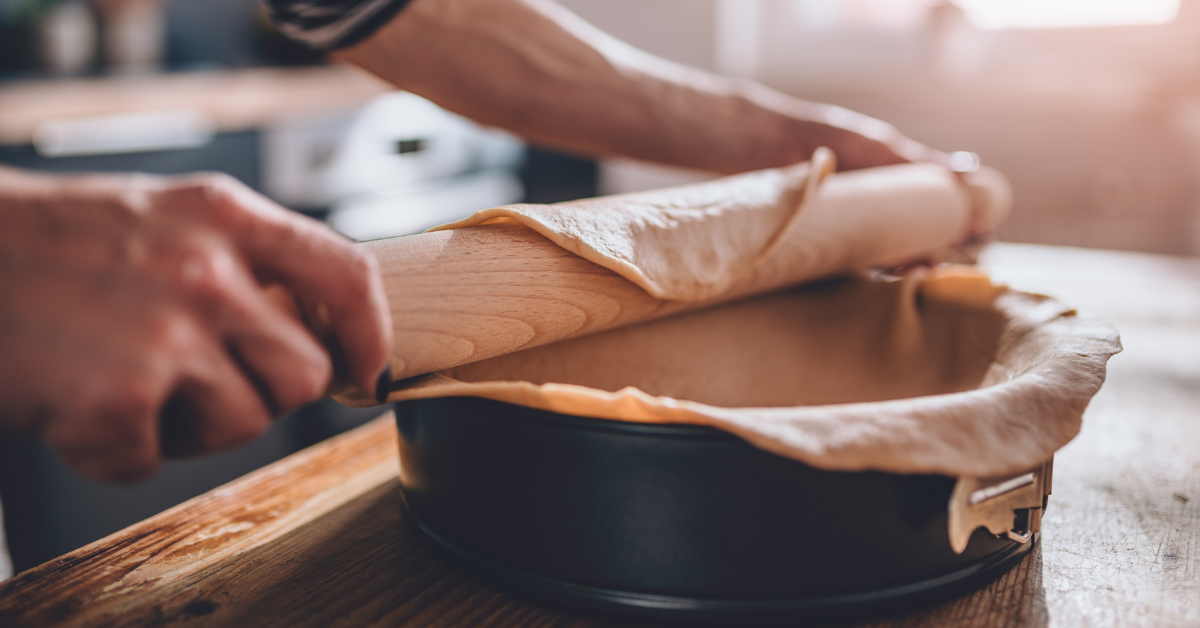 A pit crust is placed in a baking dish using a roller