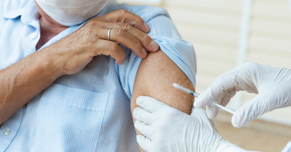 Man in mask gets COVID-19 vaccine