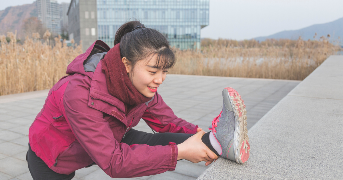 Woman stretching outside in winter