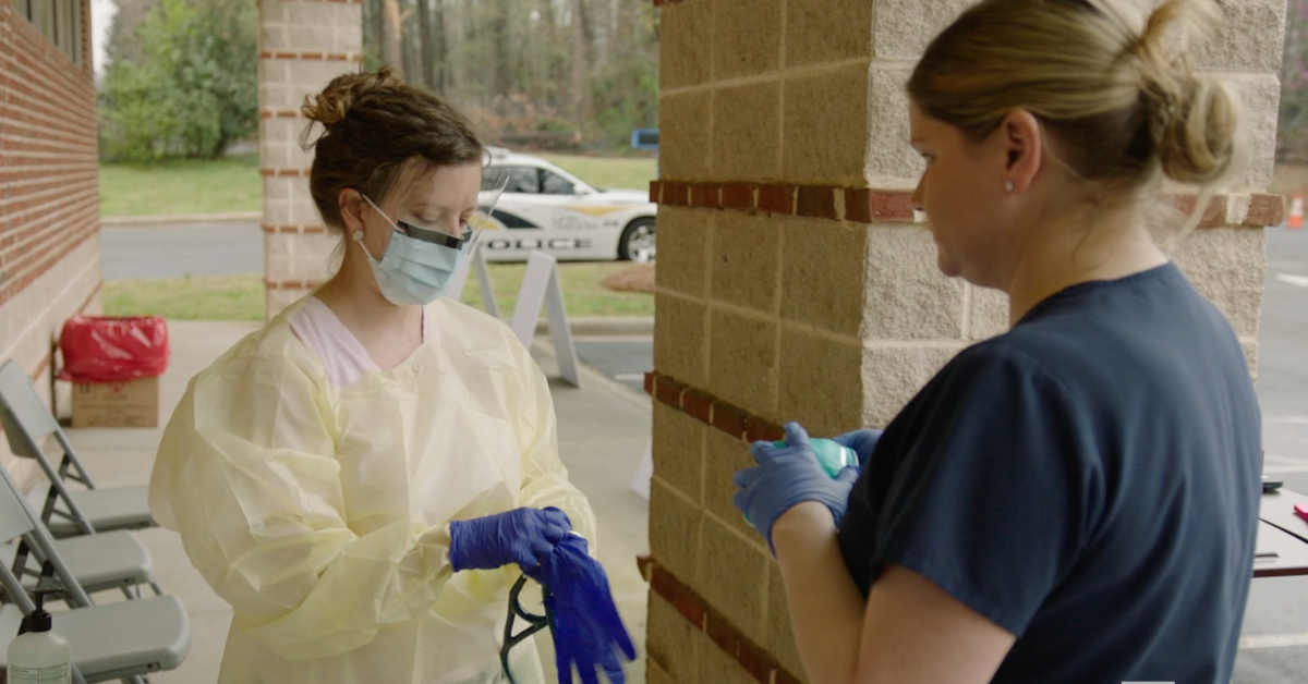 Doctor puts on PPE at COVID-19 testing site